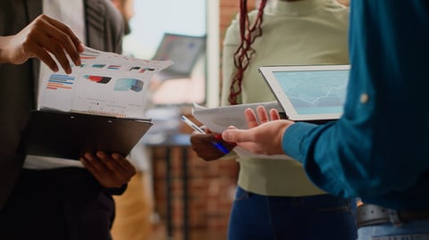 diverse-colleagues-working-business-partnership-with-charts-information-data-research-planning-group-presentation-analyzing-graphs-report-with-coworkers-files-tablet-close-up