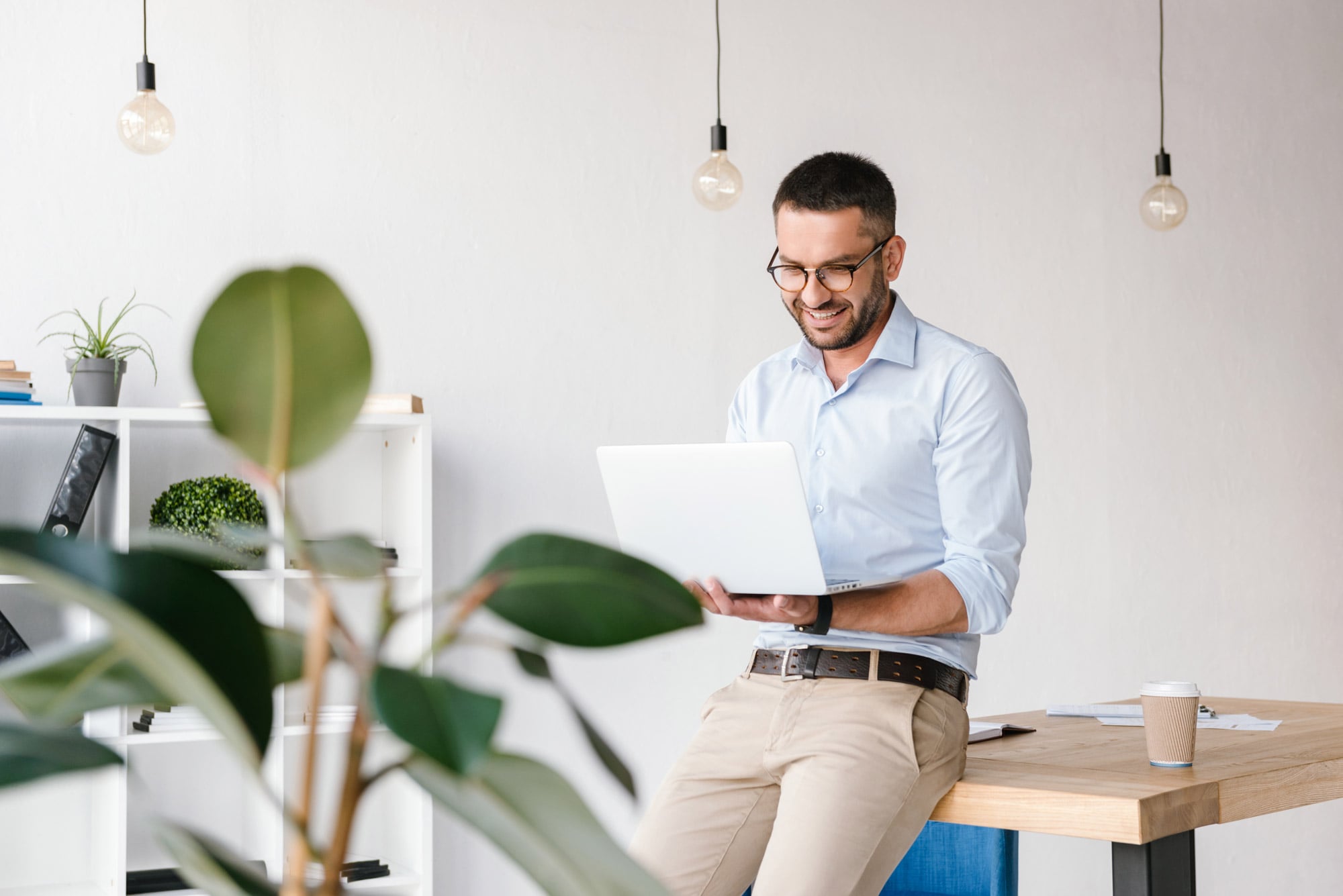 smiling-satisfied-man-30s-wearing-white-shirt-sitting-table-office-having-business-chat-silver-laptop